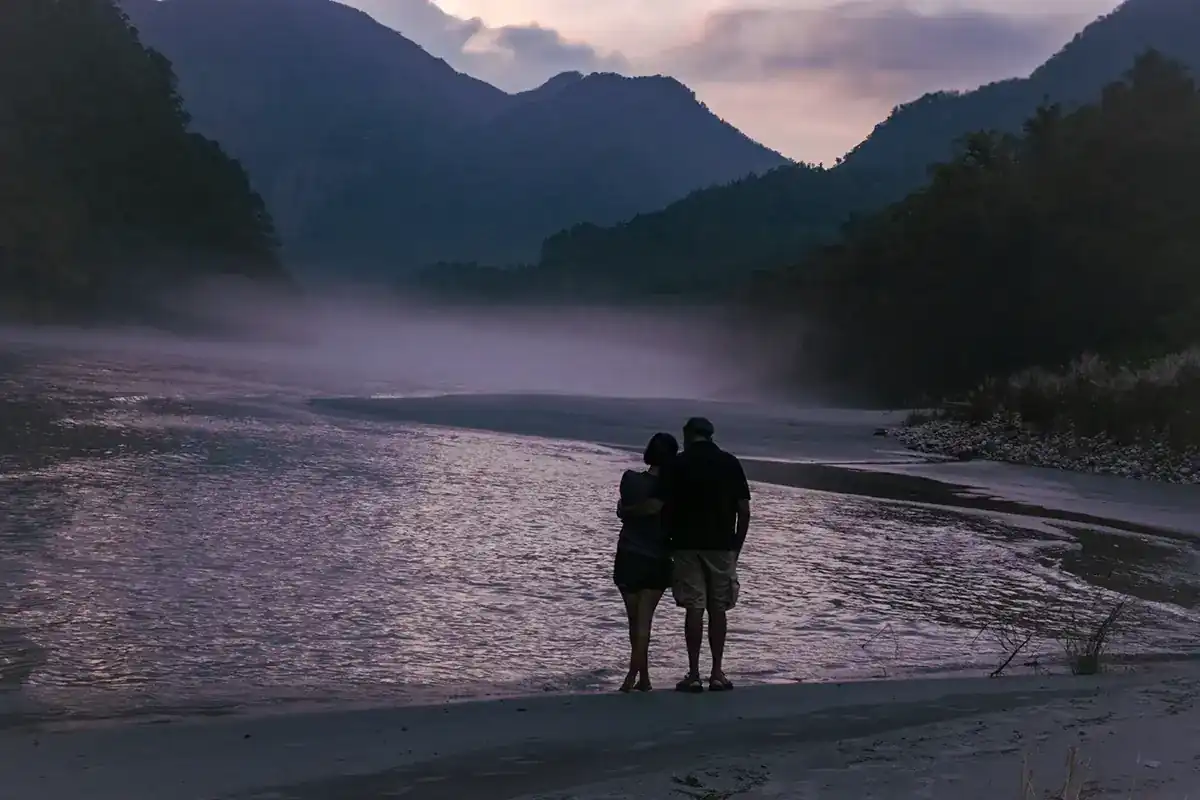 Couple standing together by the Ganga at dusk near Atali Ganga
